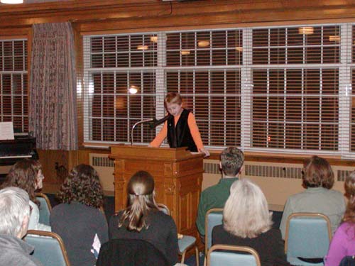 Young child at podium giving a presentation to adults.