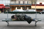Man sleeping on a street bench.
